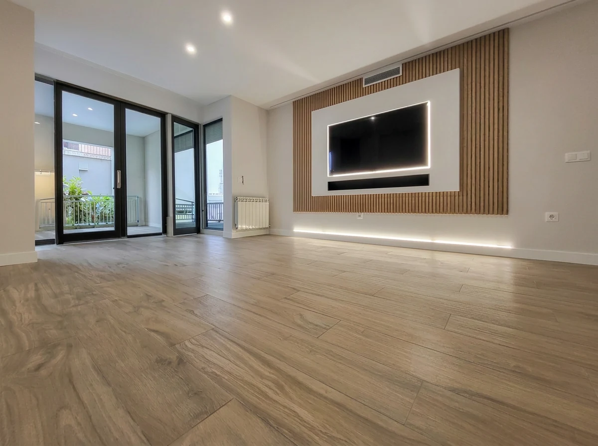 Salón reformado en Pozuelo de Alarcón con panel de madera y luz natural